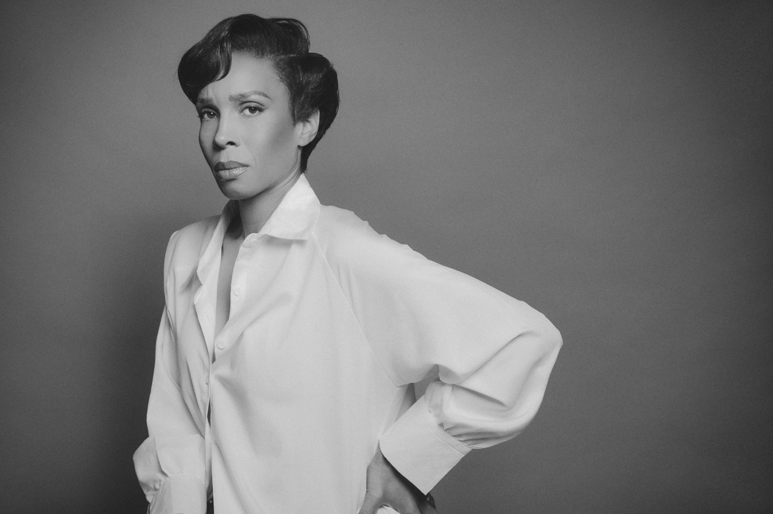 Black-and-white editorial portrait in a white shirt